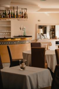 un restaurante con mesas, sillas y una barra en Hotel Villa Maria Au Lac - Estella Hotels Italia, en Toscolano Maderno