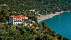 un gran edificio en una colina junto a una playa en Marabou Hotel Chorefto en Chorefto