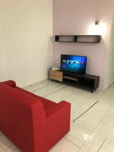 een woonkamer met een rode bank en een tv bij Casa vacanze Capo Rizzuto 3 in Ovile la Marinella