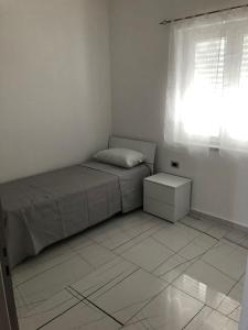um pequeno quarto com uma cama e uma janela em Casa vacanze Capo Rizzuto 3 em Ovile la Marinella