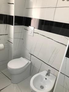 a white bathroom with a toilet and a sink at Casa vacanze Capo Rizzuto 3 in Ovile la Marinella