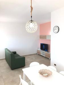 uma sala de estar com uma cadeira verde e uma mesa em Casa vacanze Capo Rizzuto 1 em Ovile la Marinella