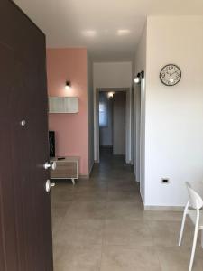 a hallway with a clock on the wall and a clock on a wall at Casa vacanze Capo Rizzuto 2 in Ovile la Marinella