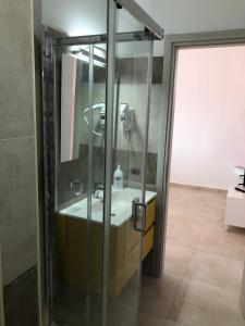 La salle de bains est pourvue d'une douche en verre et d'un lavabo. dans l'établissement Casa vacanze Capo Rizzuto 2, à Ovile la Marinella