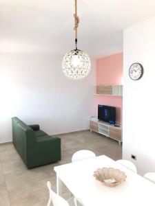 a living room with a green chair and a table at Casa vacanze Capo Rizzuto 2 in Ovile la Marinella