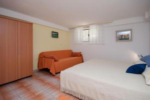 a bedroom with a bed and a couch at Apartments Milan in Poreč