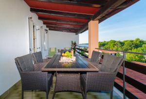 a dining room table and chairs on a balcony at Apartments Ester in Funtana