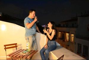 a man and a woman standing on a roof drinking at Aram Galata Suites in Istanbul