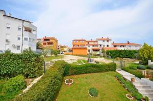 a garden in the middle of a city with buildings at Apartments Bovarovic in Pula