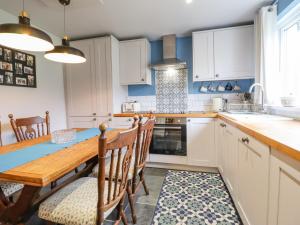 a kitchen with a wooden table and a dining room at 2 Pant Y Celyn in Caernarfon