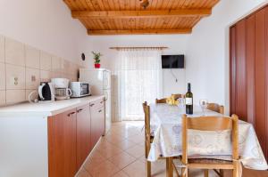 a kitchen with a table and a white refrigerator at Apartment Marija Durdica in Lopar