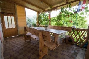une table et un banc en bois dans une chambre avec fenêtre dans l'établissement Apartments Zeljka, à Mundanije
