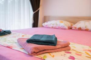 a pile of towels sitting on top of a bed at Апартамент Царски бриз in Sozopol