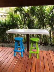 a table and two stools on a wooden deck at Villa Wolaba in Puerto Viejo