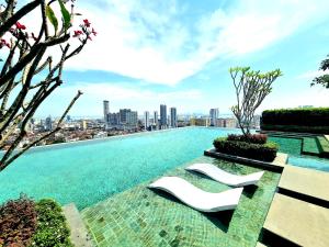 a pool on the roof of a building with white chairs at Beacon Executive Suites - Penang in George Town