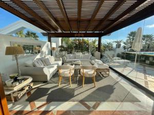 uma sala de estar com um sofá, uma mesa e cadeiras em Luxurious and light 3 bedroom penthouse em Estepona