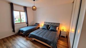 a bedroom with two beds and a window at Les retrouvailles des Ducs by Vindihouses - piscine chauffé toute l'année - billard in Magnien +13 photos