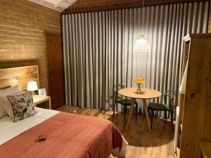 a hotel room with a bed and a table with chairs at Chalés Ceuci in Santo Antônio do Pinhal