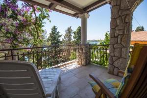 a patio with chairs and a balcony with a view at Apartments Luka in Mali Lošinj