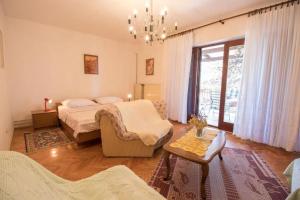 a bedroom with a bed and a couch and a table at Apartments Luka in Mali Lošinj