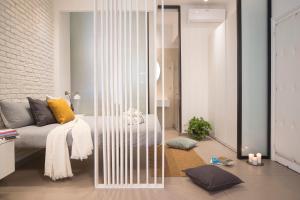 a living room with a bed and a glass wall at Stay In Ortigia in Siracusa