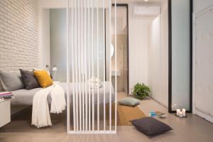salon z łóżkiem i szklaną ścianą w obiekcie Stay In Ortigia w Syrakuzach