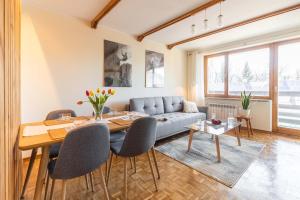 Apartament Cztery Tulipany Zakopane في زاكوباني: غرفة معيشة مع أريكة وطاولة