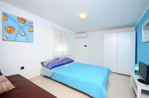 a bedroom with a bed and a flat screen tv at Apartments Ivan Marina in Krk