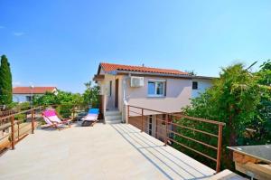 a patio with two chairs and a house at Apartments Ivan Marina in Krk