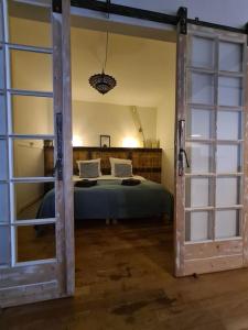 une porte ouverte sur une chambre avec un lit dans l'établissement Lo.f.t ô village, à Monflanquin
