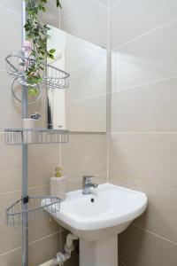 y baño con lavabo blanco y espejo. en Gorgeous apartment Wood Green Palmers Green, en Palmers Green