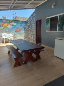 a wooden picnic table in a room with a mural at Casa com Piscina e 3 Quartos Climatizados 8km do Centro in Palmas