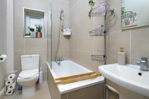 y baño con bañera, aseo y lavamanos. en Gorgeous apartment Wood Green Palmers Green, en Palmers Green