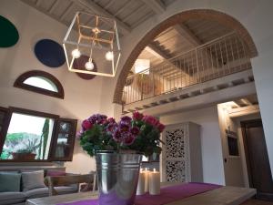 una sala de estar con un jarrón de flores sobre una mesa en San Ruffino Apartments, en Lari