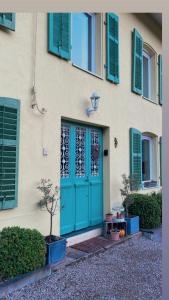 een gebouw met een blauwe deur en groene ramen bij Le moulin de l Epine in Taintrux
