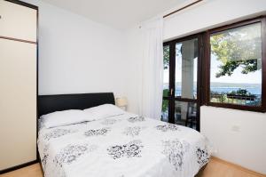 a bedroom with a bed and a large window at Apartments Petra in Crikvenica