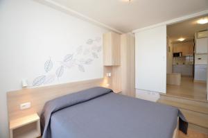 a bedroom with a blue bed and a white wall at Apartments Marija in Cres