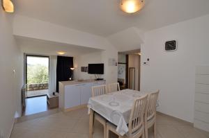 a kitchen and dining room with a table and chairs at Apartments Marija in Cres