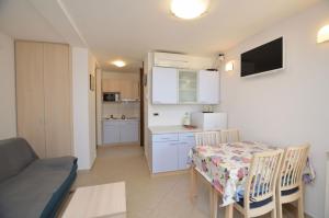 a kitchen and a dining room with a table and chairs at Apartments Marija in Cres