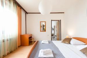 een slaapkamer met een groot bed en een groot raam bij Apartments Ivanka in Krk