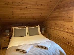 A bed or beds in a room at Red Squirrel log cabin with hot tub