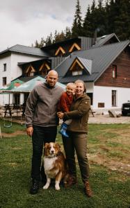 een familie die naast een hond in een veld staat bij Penzion Panský dům in Kvilda