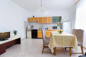 una cucina con tavolo e sedie e una cucina con mobili gialli di Apartment Milka i Milan a Senj