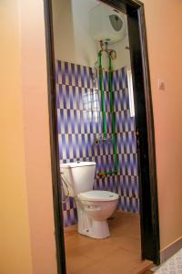 La salle de bains est pourvue d'une douche et de toilettes. dans l'établissement RESIDENCES AMADIRA, à Parakou