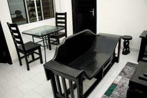 - un piano noir dans une pièce avec des chaises et une table dans l'établissement RESIDENCES AMADIRA, à Parakou
