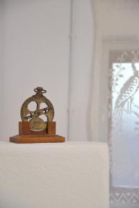 un reloj sentado sobre una mesa en Milos Apartments Kardapis Ground Floor en Klima