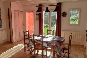 a dining room with a table and chairs and a window at Gîte Rouge Safran pour 4 personnes in Marsac-en-Livradois