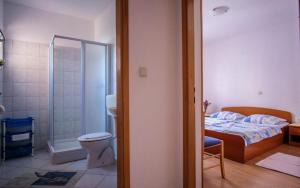 een badkamer met een bed, een douche en een toilet bij Apartments Jasmin in Barbat na Rabu +49 foto's