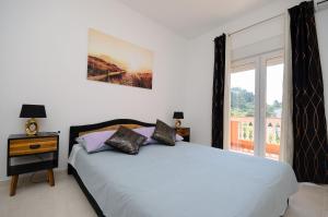 een witte slaapkamer met een bed en een raam bij Apartments Darko in Rab