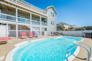a swimming pool in front of a building at K2095 Clam I Am. Semi-Oceanfront, Elevator, Private Pool, Rec Room, Theater in Southern Shores